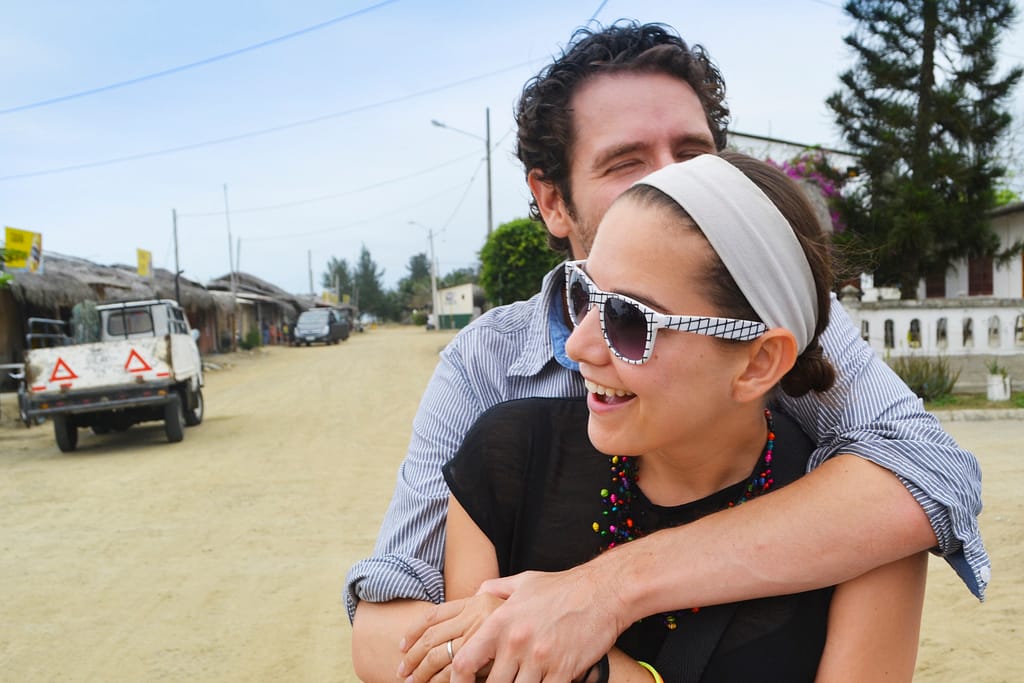A man and a woman hug on a street in Ecuador