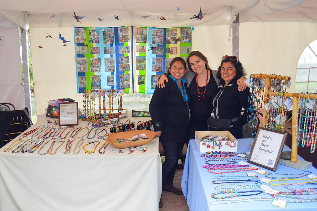 Members of the artisan cooperative Mujeres: Cambia in front of a booth at a festival in Cuenca, Ecuador