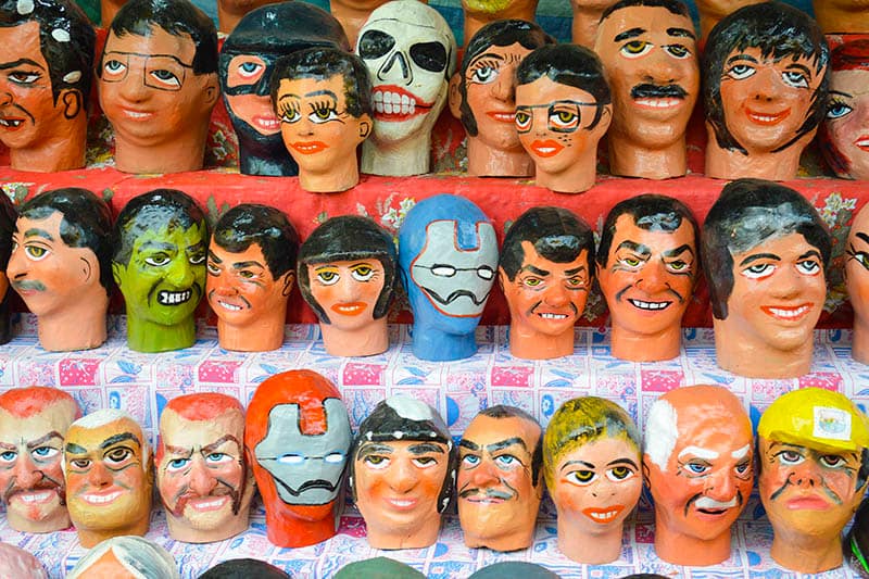 Papier mache painted mannequin heads lined up at a festival in Loja, Ecuador