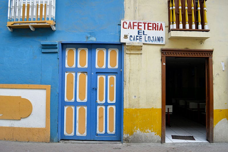 Two doorways, one painted blue and yellow in Loja, Ecuador