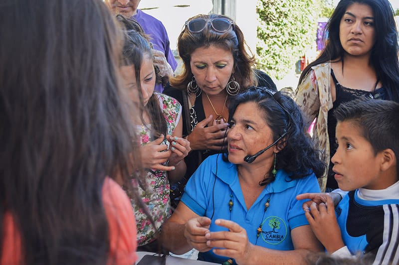 A member of Mujeres: Cambia describes the paper bead making process to a crowd at a street festival in Cuenca, Ecuador
